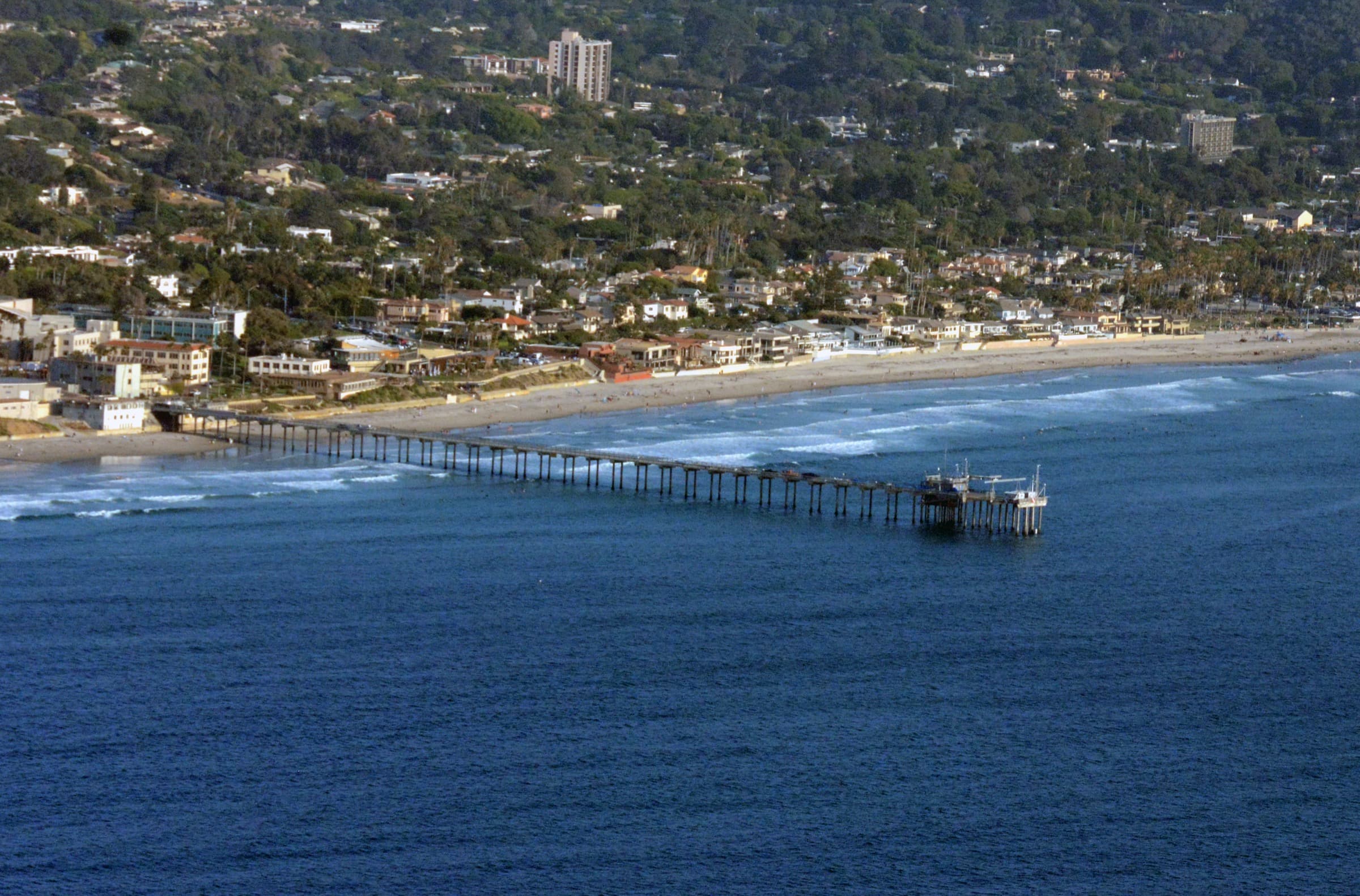 La Jolla Shores beach with hillside homes climbing the bluff above the sand